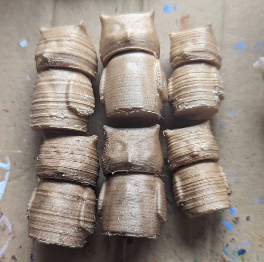 Two rows of the three sets of owls, lying on their backs. The furthest left set have rings of texture, like wood grain, the same as the small ones on the right. They also have more imperfections than the smooth ones in the middle.